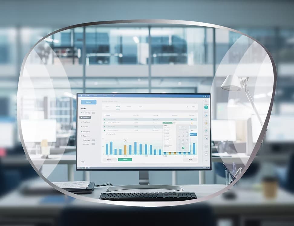An office desk and computer monitor seen through a lens