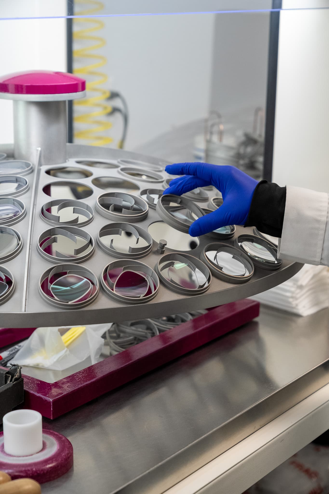 A technician loading lenses into a coating dome at EyeKraft