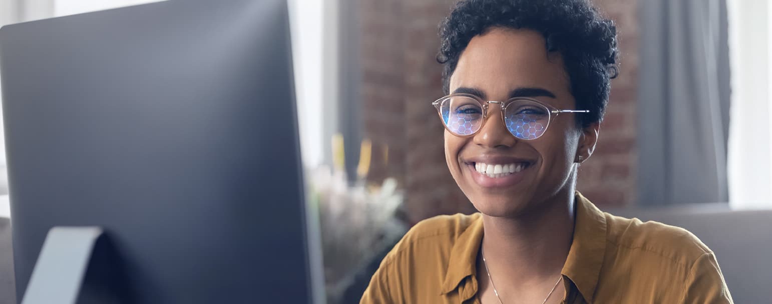 Woman wearing glasses with DLS Ultimate+ lenses at her computer