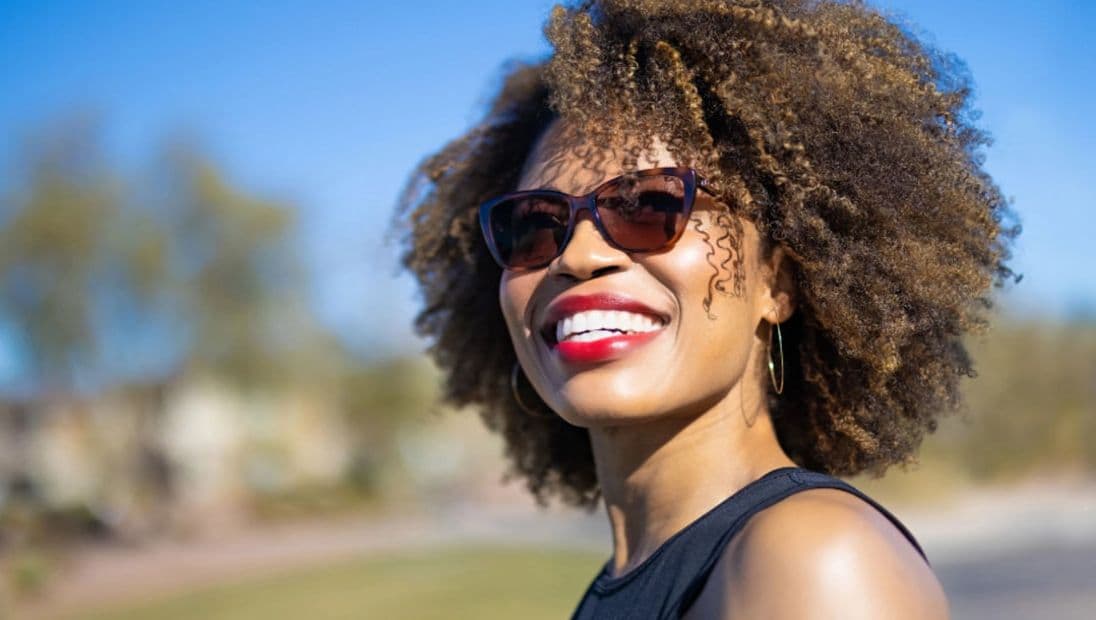 A woman outdoors in light-reactive lenses darkened by the sun